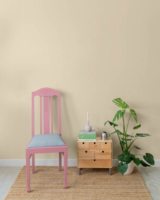 Wand mit violettem Stuhl im Farbton Beige gestrichen.